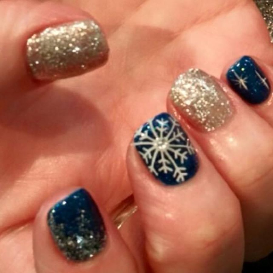 Navy and gold glitter snowflake winter accent nails on a gel manicure in OKC